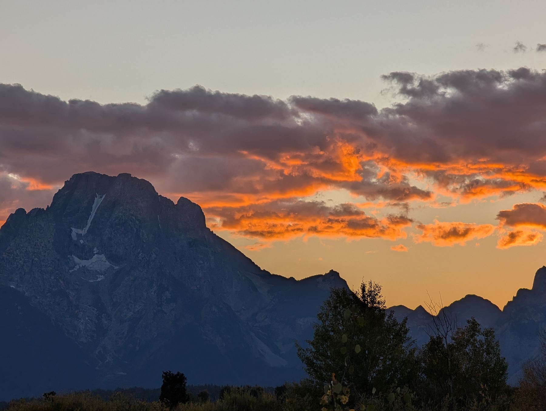 Mount Moran silhouetted against a fiery orange sunset