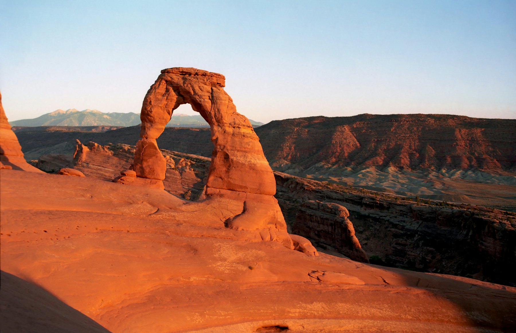 Delicate Arch lit orange by the last sun of the day
