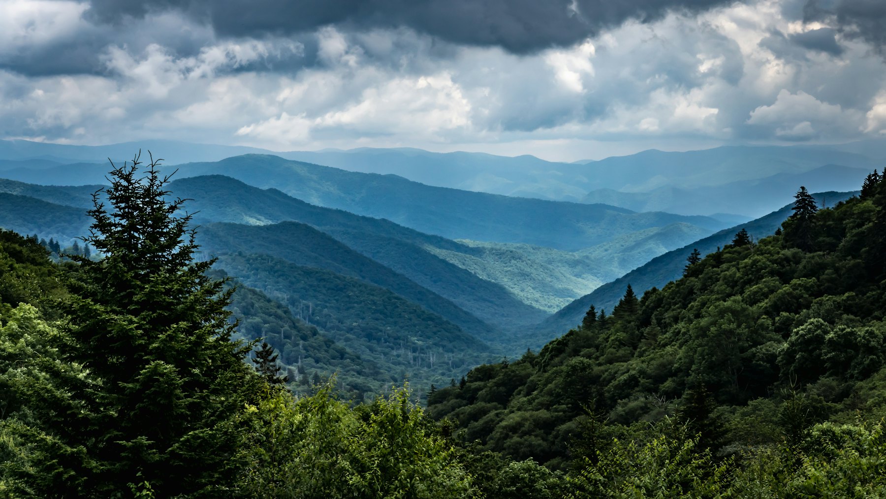 Layered forested ridges under a cloudy sky